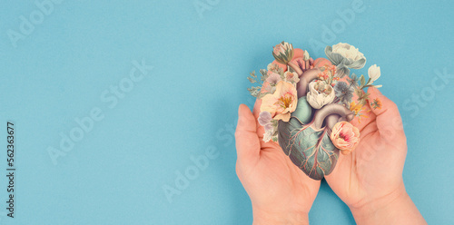 Slika na platnu Hands holding human heart with flowers, love and emotion concept,  good hearted