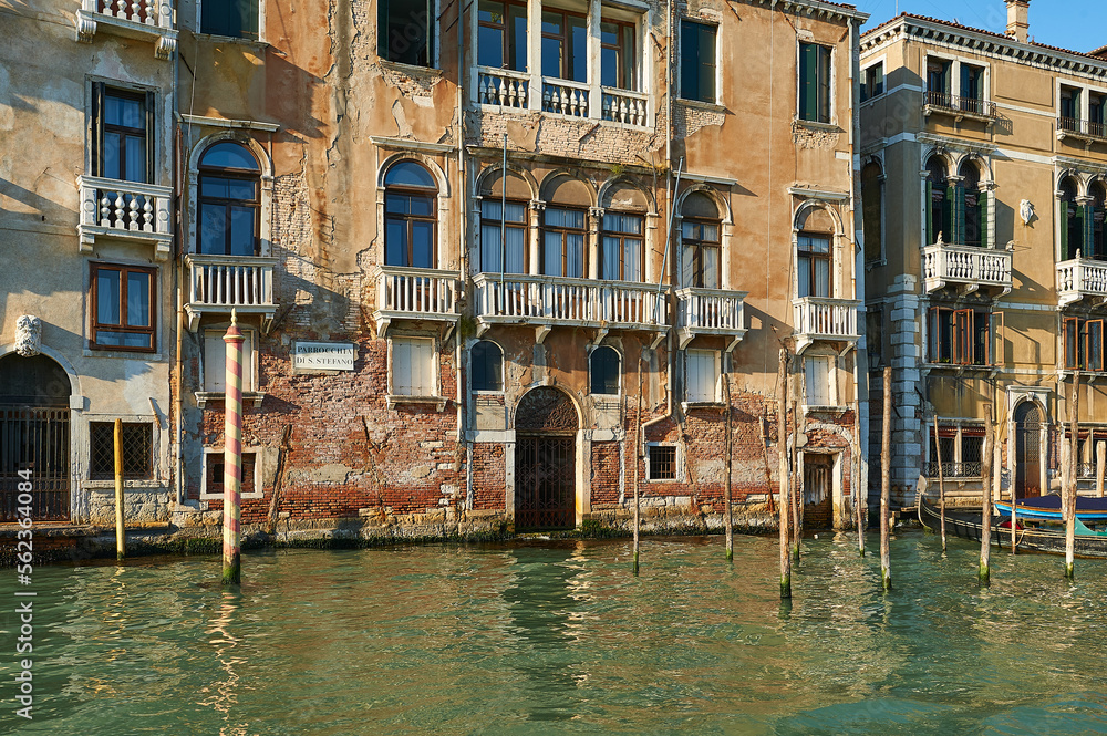 Facade of the Parish of St. Stephen in the Grand Canal in Venice with red brick in sight in poor condition due to moisture