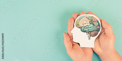 Foto Hands holding paper head, human brain with flowers, self care and mental health
