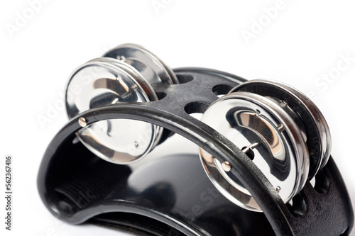 The tambourine is black, small in size and is worn on the musician's leg or arm.