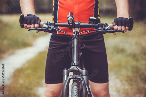 man cyclist rides in the forest on a mountain bike.