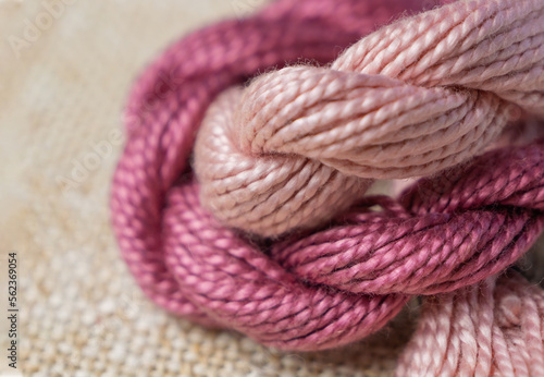 Pink-lilac sewing threads for embroidery with selective focus. Hobby, handmade, embroidery