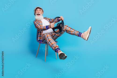 Photo of crazy overjoyed retored man dandy moving new car buy own vehicle rejoice travel trip isolated on blue color background photo