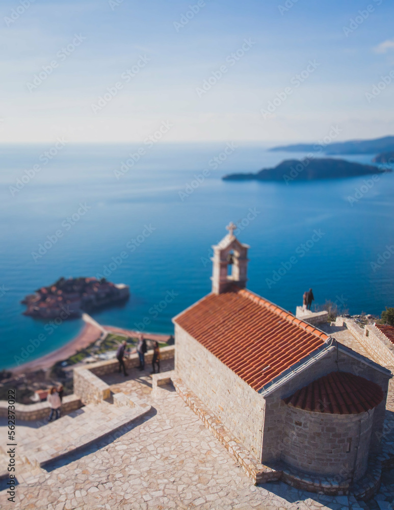 View of Sveti Stefan, a town in Budva Municipality, Budva Riviera, on the Adriatic sea coast, Saint Stephen island, Montenegro, sunny day with a blue sky, aerial drone view, travel to Montenegro