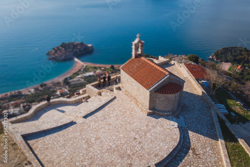 View of Sveti Stefan, a town in Budva Municipality, Budva Riviera, on the Adriatic sea coast, Saint Stephen island, Montenegro, sunny day with a blue sky, aerial drone view, travel to Montenegro © tsuguliev