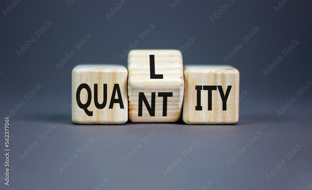 Quality and quantity symbol. Concept word Quality Quantity on wooden cubes. Beautiful grey table grey background. Business and quality and quantity concept. Copy space. Quality and quantity symbol. Concept word Quality Quantity on wooden cubes. Beautiful grey table grey background. Business and quality and quantity concept. Copy space.