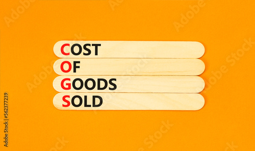 COGS cost of goods sold symbol. Concept words COGS cost of goods sold on wooden stick on beautiful orange background. Business COGS cost of goods sold concept. Copy space.