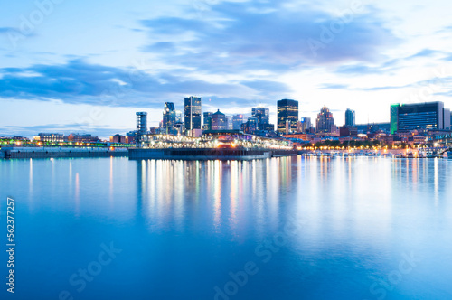 Illuminated modern buildings by Saint Lawrence River against sky during sunset photo