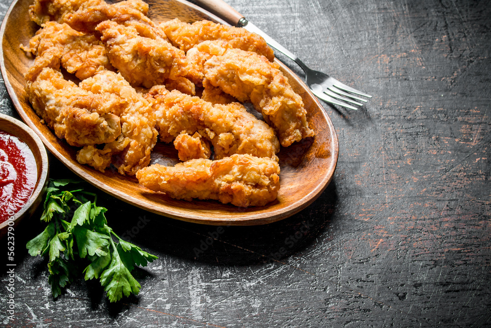 Chicken strips on a plate with greens and sauce. Chicken strips on a plate with greens and sauce.