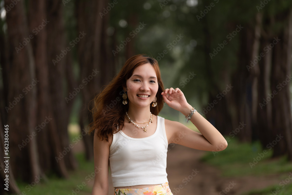 Young Asian beautiful woman traveling alone in a pine forest near the beach, feeling happy, smiling, and free. Traveler travel one day trip in a holiday. Vacation activities visit tourist attraction Young Asian beautiful woman traveling alone in a pine forest near the beach, feeling happy, smiling, and free. Traveler travel one day trip in a holiday. Vacation activities visit tourist attraction