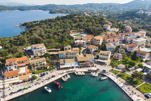 Aerial drone view of Kassiopi, village in northeast coast of Corfu island, Ionian Islands, Kerkyra, Greece in a summer sunny day, with marina, town, beach and castle © tsuguliev