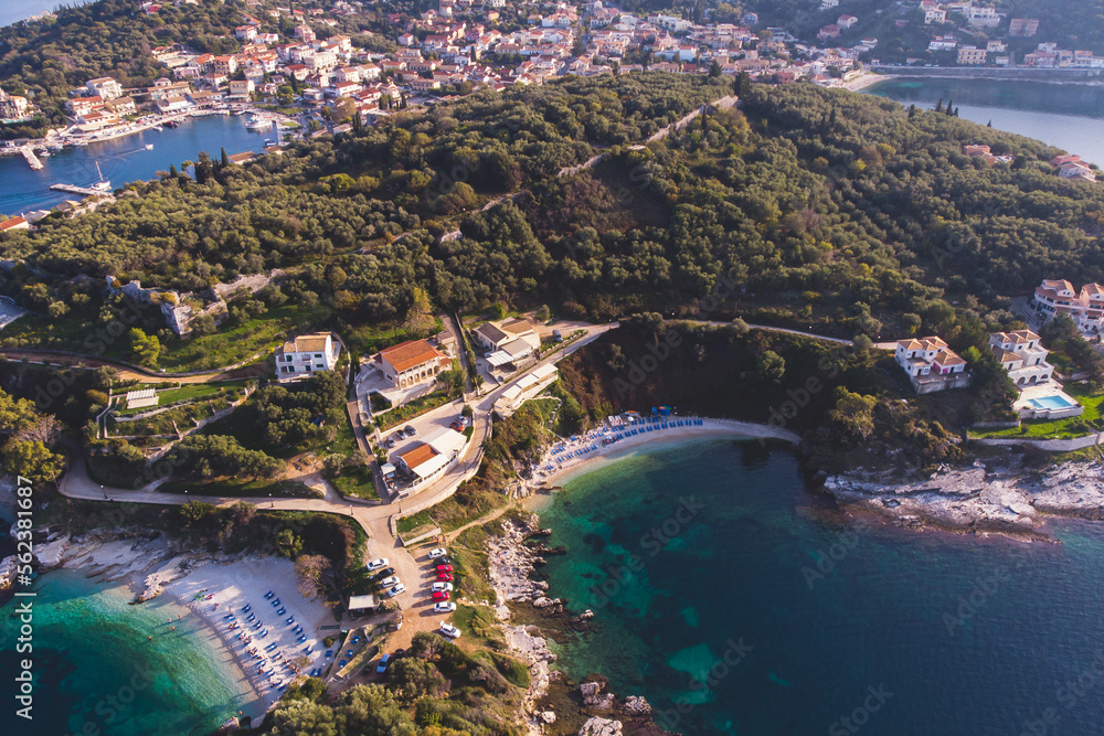 Aerial drone view of Kassiopi, village in northeast coast of Corfu island, Ionian Islands, Kerkyra, Greece in a summer sunny day, with marina, town, beach and castle