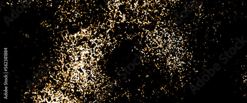 Gold sparkle glitter explosion dust particles background with bokeh, close up of the golden glitter on black background.