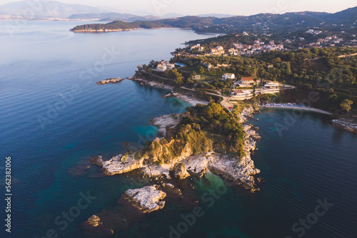 Fototapeta Naklejka Na Ścianę i Meble -  Aerial drone view of Kassiopi, village in northeast coast of Corfu island, Ionian Islands, Kerkyra, Greece in a summer sunny day, with marina, town, beach and castle