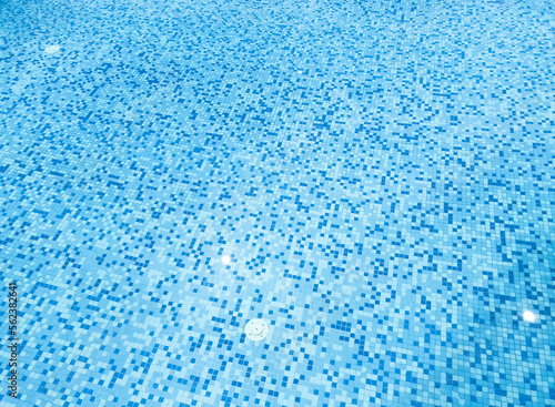 Ripple water in swimming pool with sun reflection. Background shot of pool water surface pattern. Ripple wave and clear turquoise water surface texture