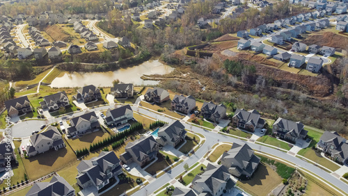 Aerial view urban sprawl and master planning subdivision with row of new development two story houses, lake and nature trail North of Atlanta, Georgia, USA photo