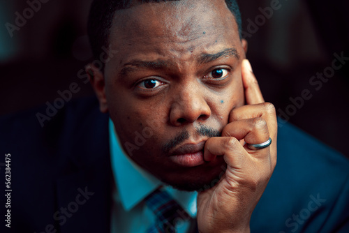Black or African American business man sitting down looking anxious and depressed