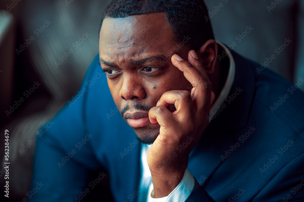 Black or African American business man sitting down looking anxious and depressed Black or African American business man sitting down looking anxious and depressed