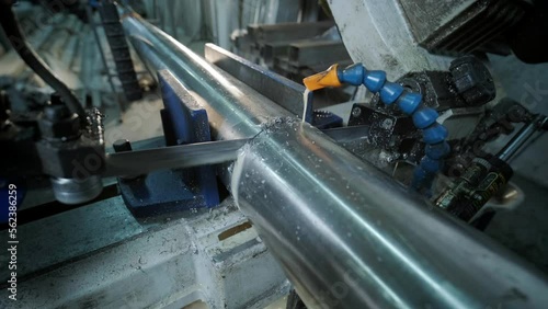 Cutting stainless steel pipes, the band saw for industrial cutting the metal stainless pipe and using the coolant heating. The industrial tool.