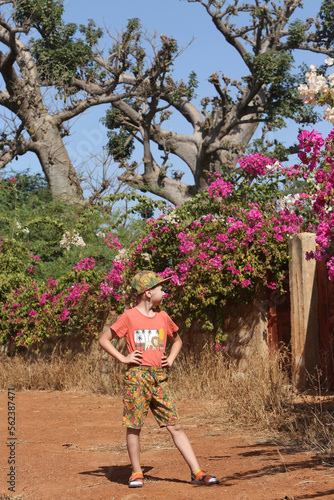 Tourist child, cute boy, fashion kid in Saly, Senegal, Africa. Active recreation, rest, sport. African travel, tourism with kid, child, boy. African nature, baobab photo