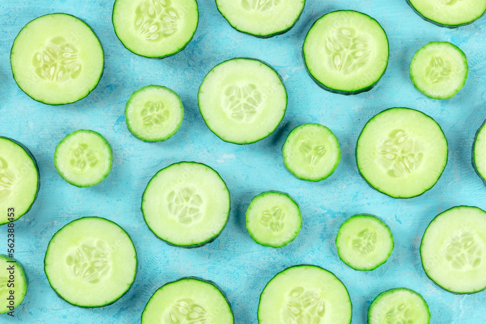 Fresh cucumber slices on a blue background, overhead flat lay shot. Healthy organic food design Fresh cucumber slices on a blue background, overhead flat lay shot. Healthy organic food design