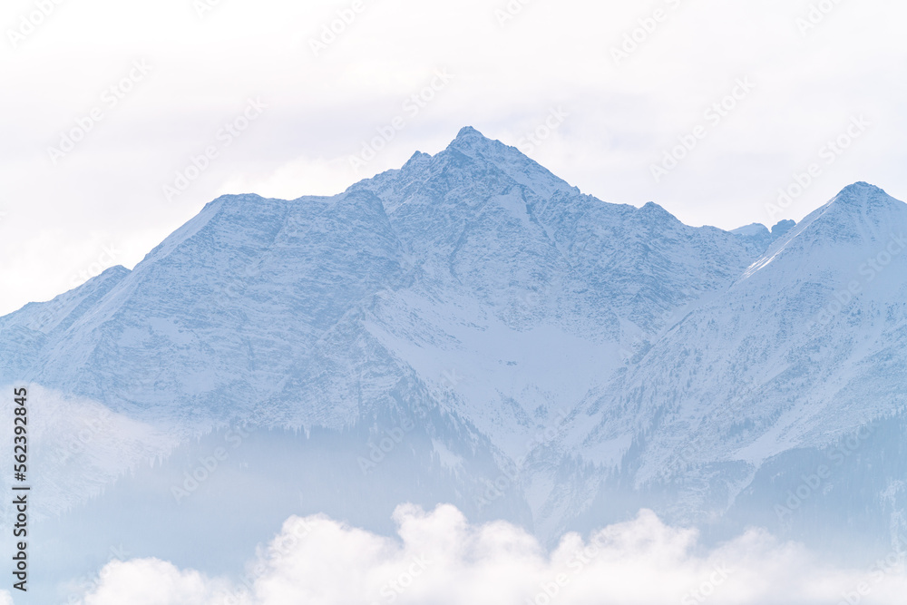 Fototapeta premium Mountain peak with rocks covered in snow during winter on a sunny day in Switzerland.
