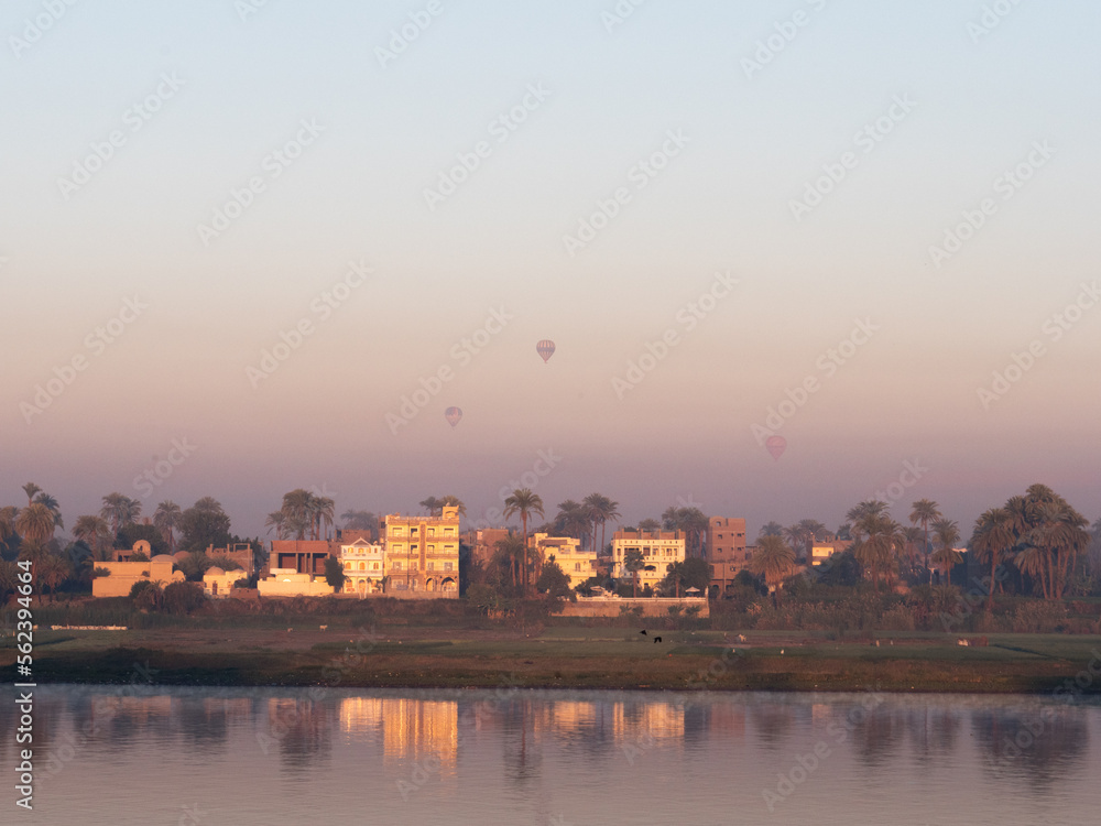 Hot air balloon flying in the background of the Nile river in Luxor, Egypt.