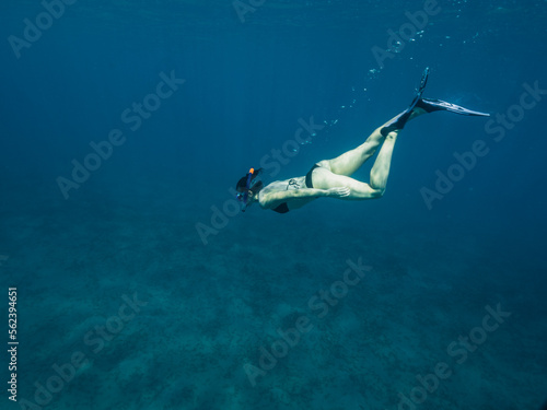 Young white caucasian woman snorkeling underwater.