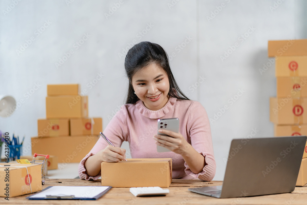 Asian businesswoman starting a successful small business Freelance work from home with laptop online shopping with online parcel delivery service, SME concept and package delivery. Asian businesswoman starting a successful small business Freelance work from home with laptop online shopping with online parcel delivery service, SME concept and package delivery.