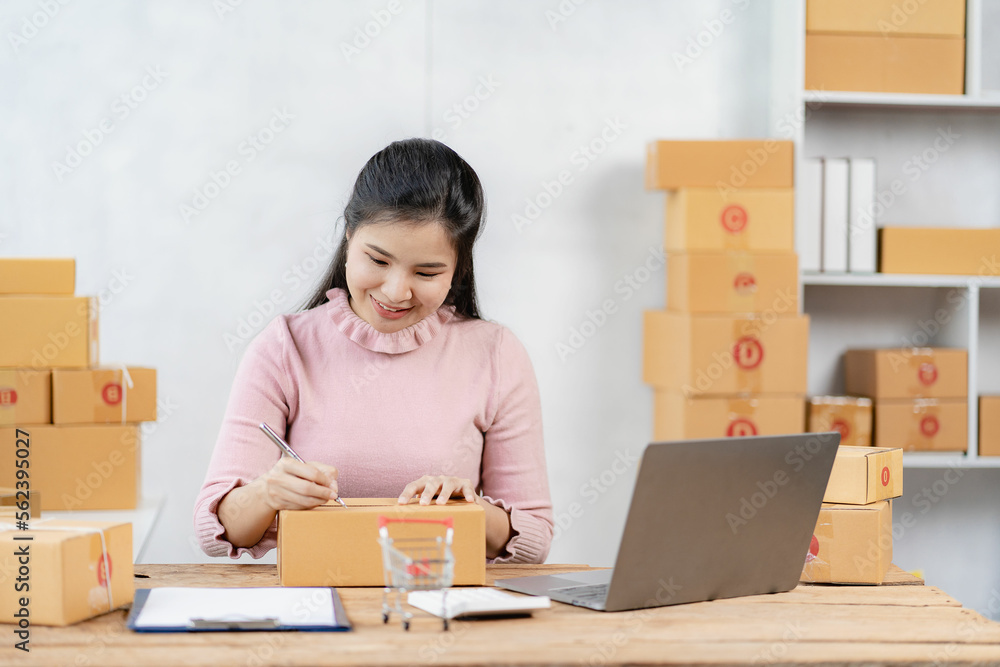 Asian businesswoman starting a successful small business Freelance work from home with laptop online shopping with online parcel delivery service, SME concept and package delivery. Asian businesswoman starting a successful small business Freelance work from home with laptop online shopping with online parcel delivery service, SME concept and package delivery.