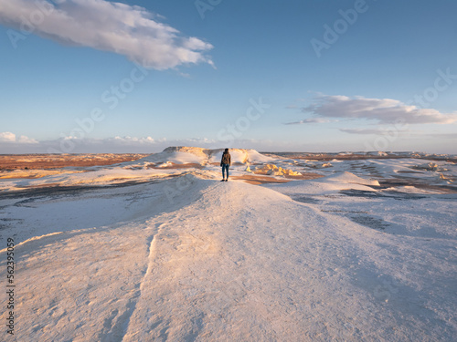 Woman standing on a hillin the landscape in Snow Mountain, White Desert, Egypt.
