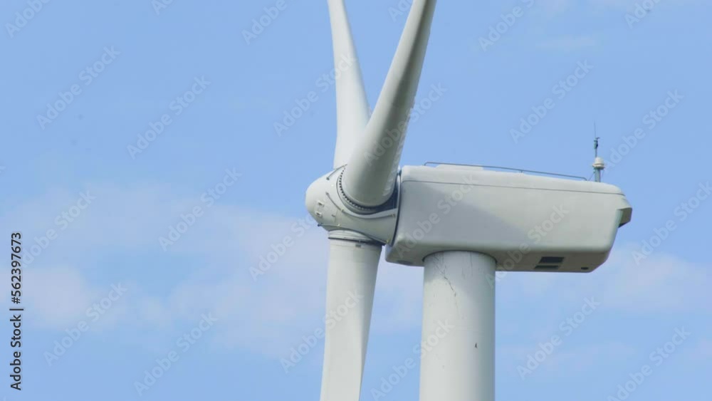 Wind turbine generator close up clean sustainable renewable energy against blue sky Wind turbine generator close up clean sustainable renewable energy against blue sky