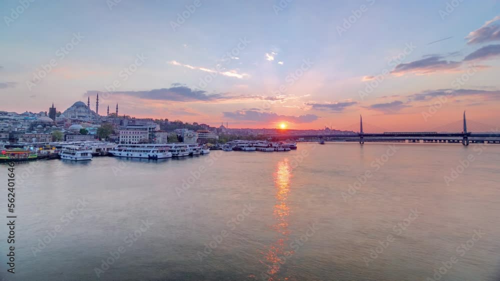 Passenger Ferries near boat station in the Golden Horn near Bosphorus at sunset panoramic timelapse, Istanbul skyline, Turkey. Mosque and bridge on background with reflection on water at sping day Passenger Ferries near boat station in the Golden Horn near Bosphorus at sunset panoramic timelapse, Istanbul skyline, Turkey. Mosque and bridge on background with reflection on water at sping day