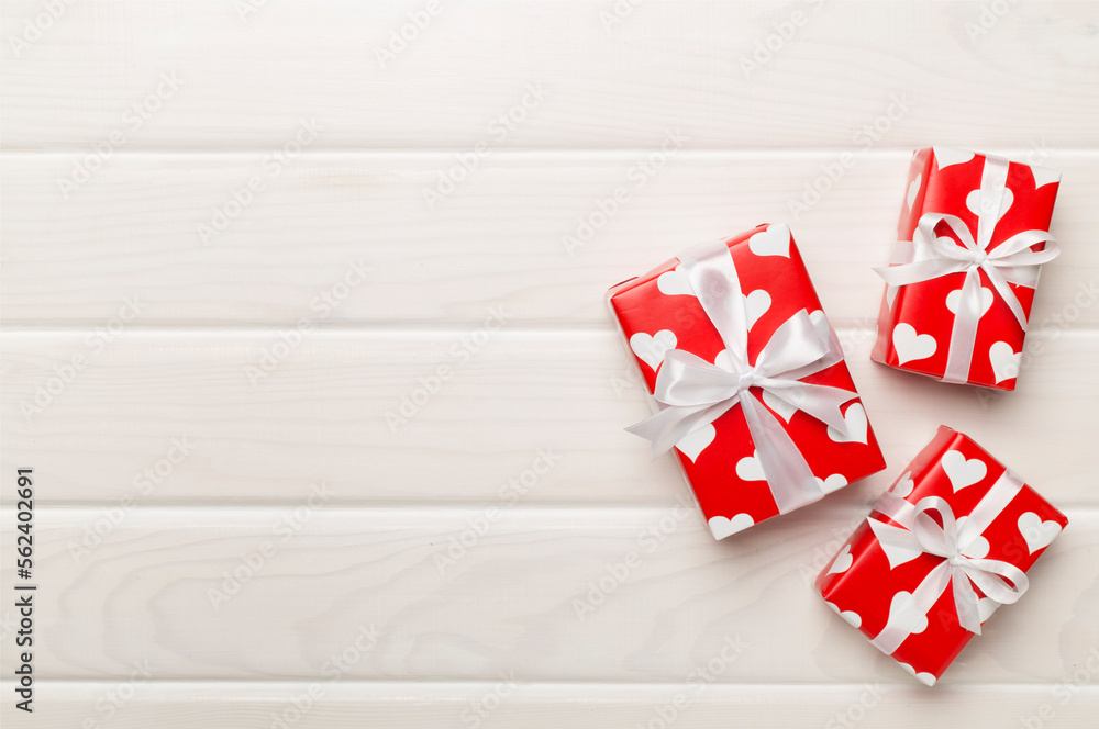 Gift boxes with hearts on wooden background, top view Gift boxes with hearts on wooden background, top view
