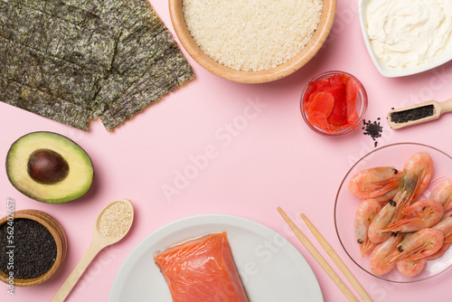 Ingredients for sushi and rolls on wooden background, top view