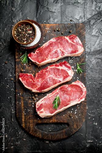 Raw marbled beef steaks with salt and spices.