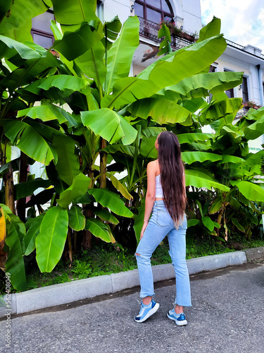 young woman long hair model behind palm trees