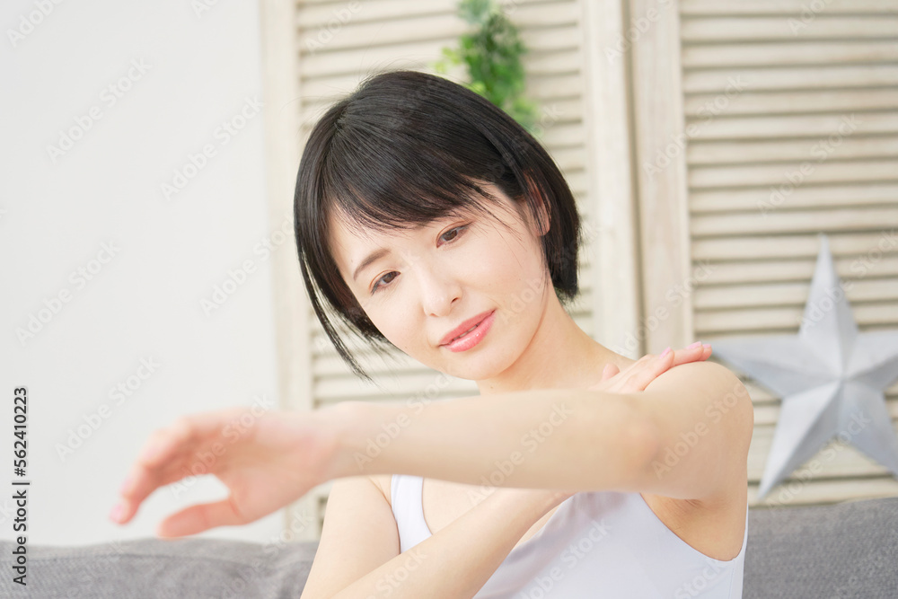 家で腕のスキンケアをする女性