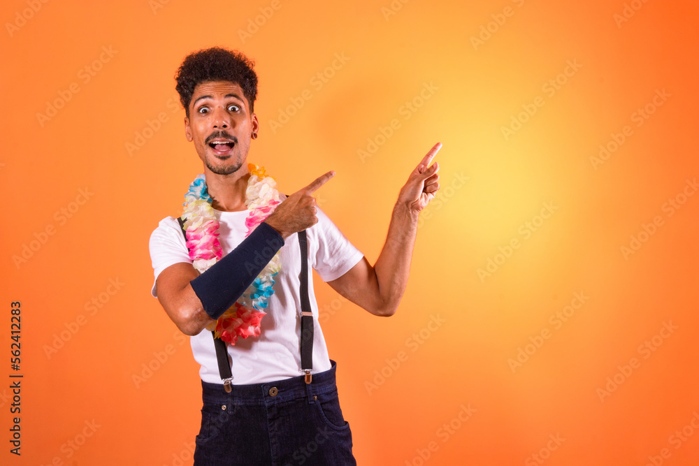 Portrait of Black Man With Carnival Props Poiting, Isolated on Orange Background Portrait of Black Man With Carnival Props Poiting, Isolated on Orange Background