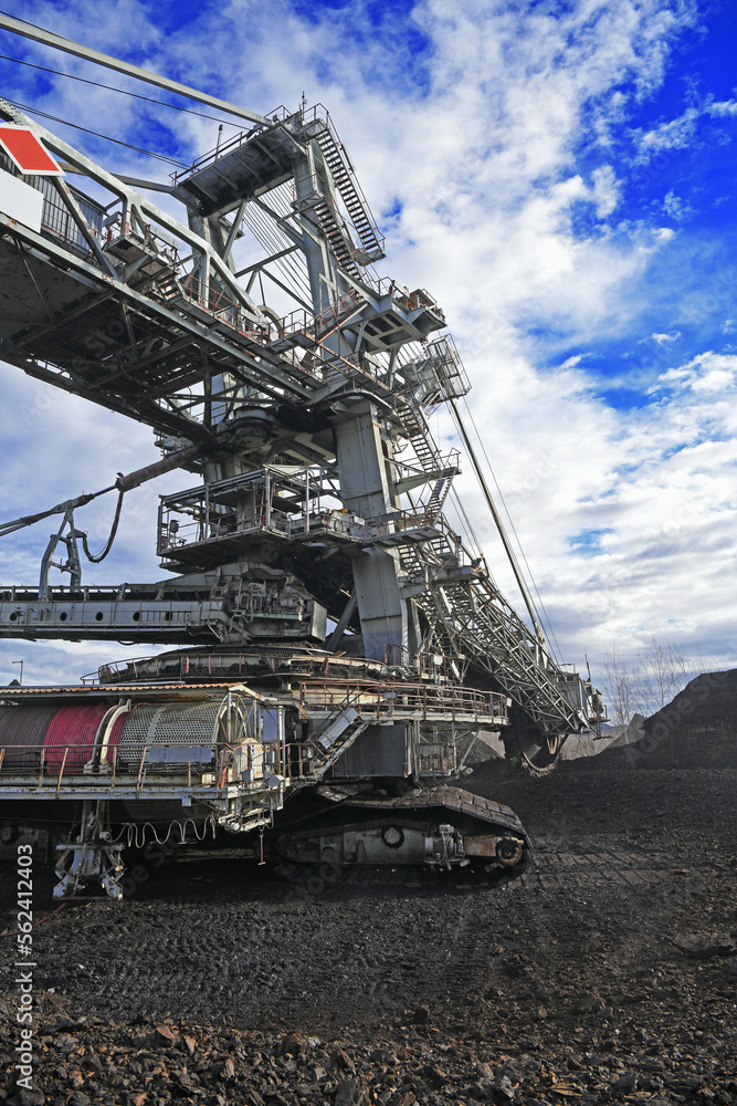 Bucket-wheel excavator during excavation at the surface mine. Huge excavator on open pit mine.