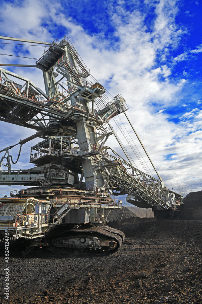 Bucket-wheel excavator during excavation at the surface mine. Huge excavator on open pit mine.