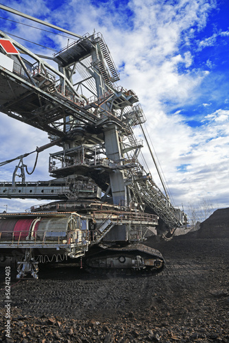 Bucket-wheel excavator during excavation at the surface mine. Huge excavator on open pit mine.