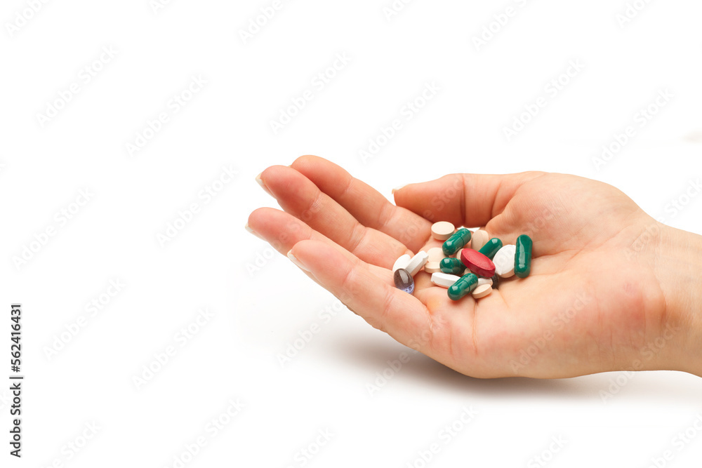 Mano de mujer con la palma abierta con medicamentos pastillas sobre un fondo blanco liso y aislado. Vista de frente y de cerca. Copy space Mano de mujer con la palma abierta con medicamentos pastillas sobre un fondo blanco liso y aislado. Vista de frente y de cerca. Copy space