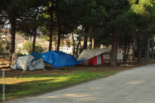Some homeless tents in forest near road. Sad situation of America