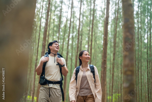 Happy Asian family couple travel nature on summer holiday vacation trip. Man and woman backpacker enjoy and fun outdoor active lifestyle hiking together in pine forest mountain. © CandyRetriever 