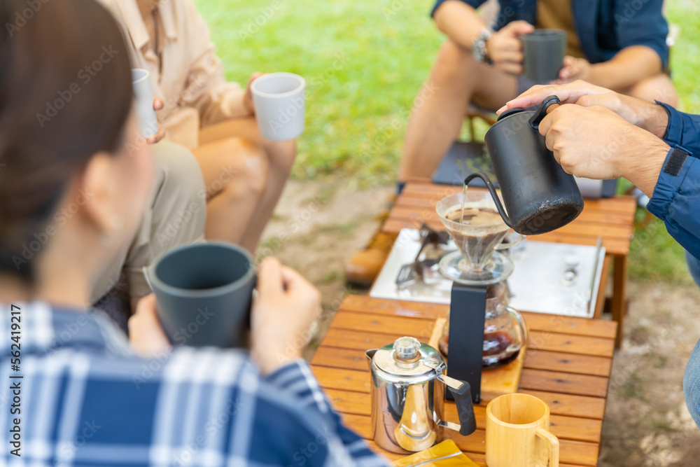 Group of Asian Man and woman friends having breakfast and making brewed coffee at camp in the morning. People enjoy and fun outdoor lifestyle travel nature and camping together on summer vacation.