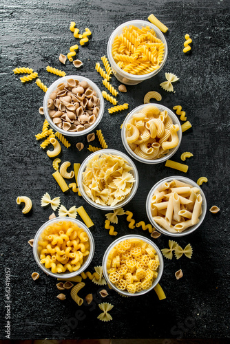 Pasta background. Different dry pasta in bowls.