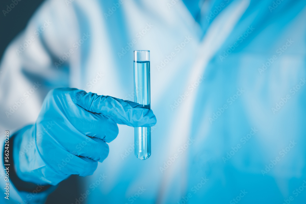 Scientist hand hold test tubes filled with blue sample chemicals in chemistry science laboratory. Glassware in medical research. Scientific lab for Biotechnology. Scientist hand hold test tubes filled with blue sample chemicals in chemistry science laboratory. Glassware in medical research. Scientific lab for Biotechnology.
