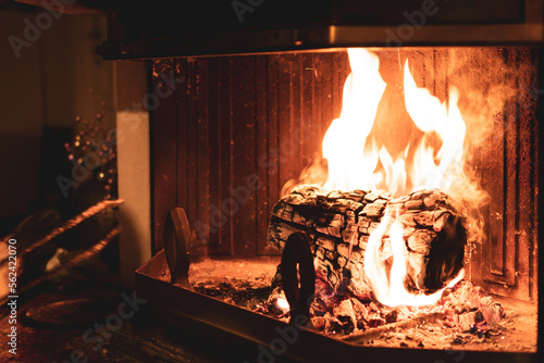 Log of wood burning in a fireplace inside a house  hearth
