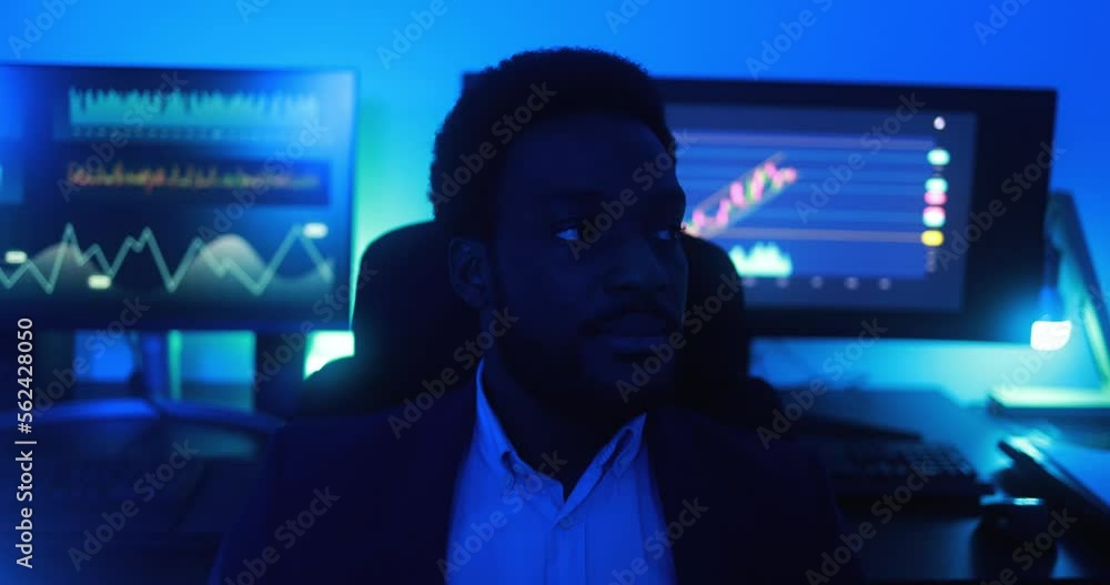 African trader working inside office at night time - Trading and technology concept African trader working inside office at night time - Trading and technology concept